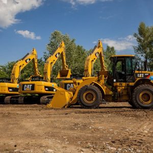 Four yellow excavators at an outdoor construction site in Kyiv, Ukraine.